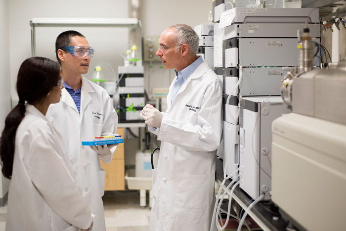 Xuntian Jiang, PhD speaks with Daniel S. Ory, MD, (right) and Rohini Sidhu, (far left).